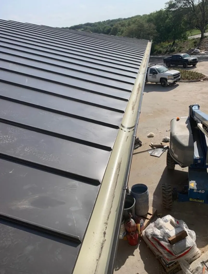 Standing seam panel and gutter detail on a metal roofing jobsite in Tyrone
